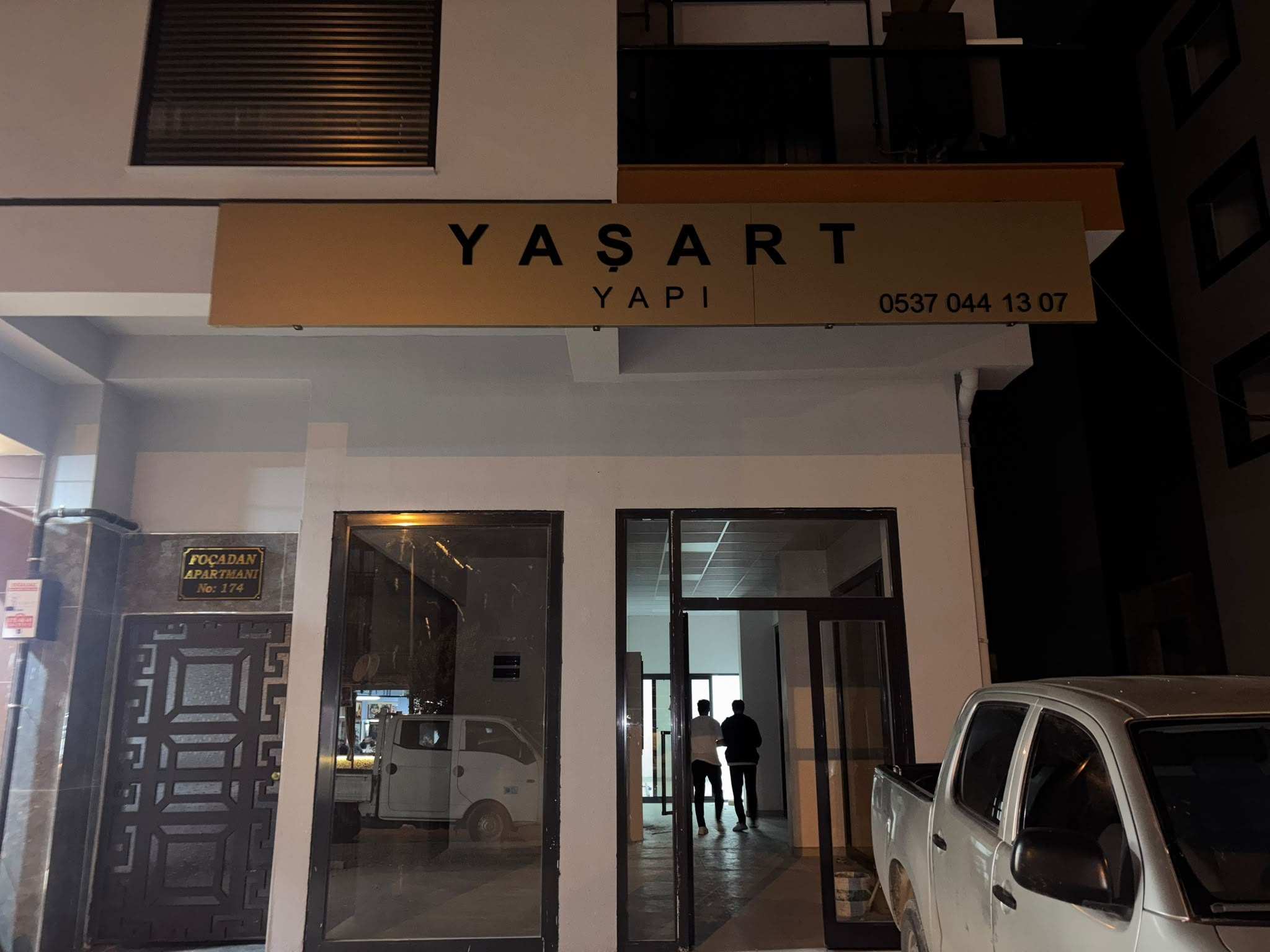 YAŞART YAPI dükkânının girişi gece: cam vitrin ve üstündeki tabela